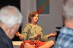 Theaterbild: Frau im Schneidersitz